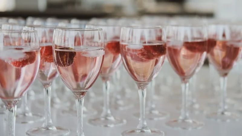 Chilled white wine being poured into a glass alongside salmon dish